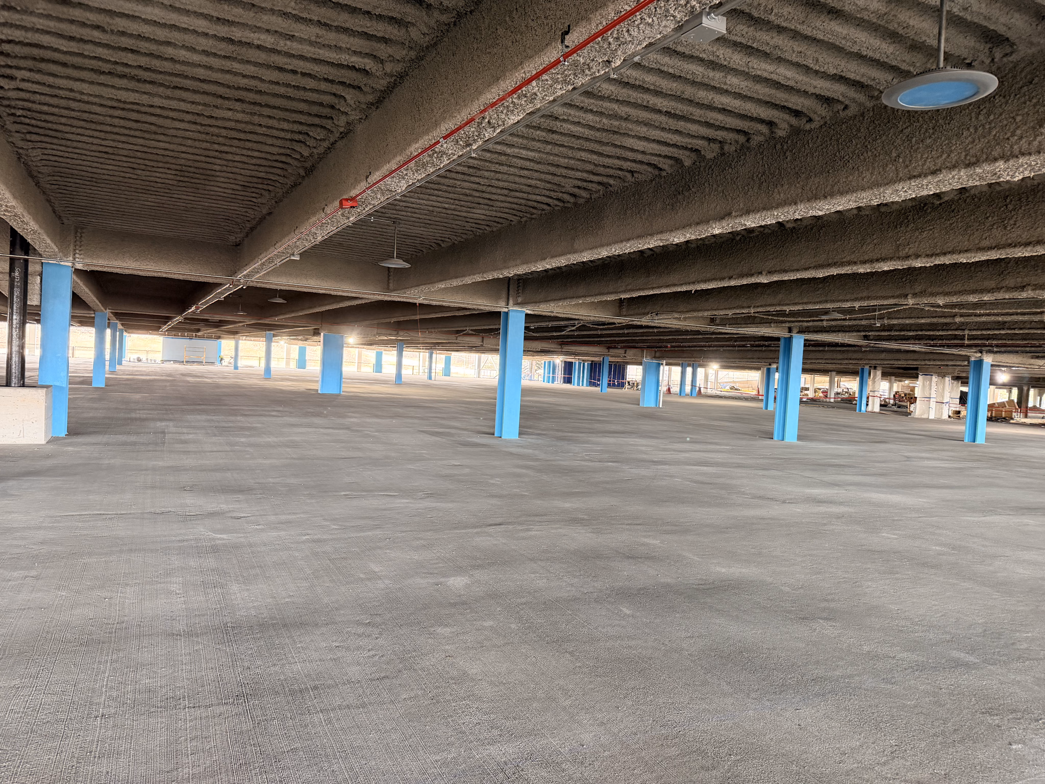 Open parking deck level with a freshly finished concrete surface ready for marking.